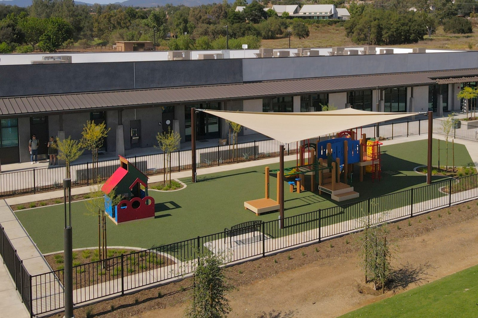Aerial view of a school campus courtyard playground with shade sail